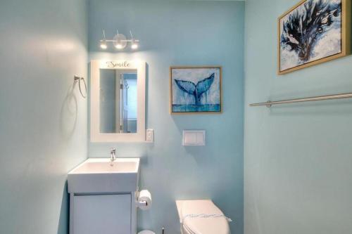 een badkamer met een wastafel, een toilet en een spiegel bij Just Like Paradise in Oak Island