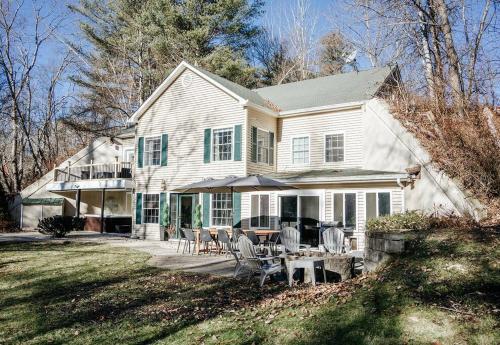 a large white house with a table and chairs at New! Mountain Retreat HotTub, Fire Pit, Pool Table in Thornton