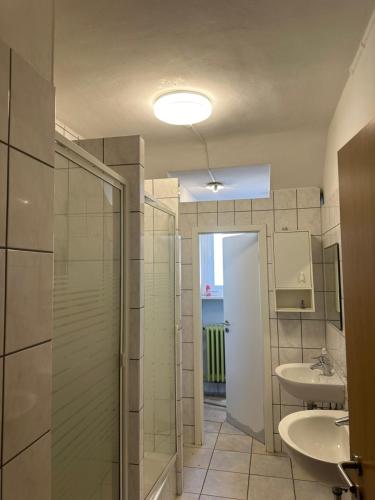 ein Bad mit 2 Waschbecken und einer Dusche in der Unterkunft Schönes Apartment in Essen in Essen