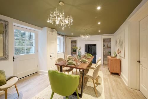 uma sala de jantar com uma mesa e cadeiras e um lustre em The Haze House - 4 Bed Townhouse em Bath