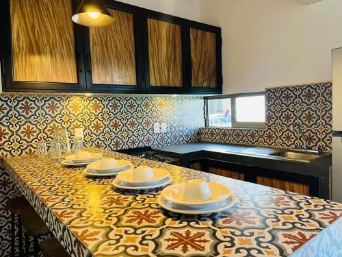 una cocina con una mesa con platos y platos. en Hotel & Suites Mar y Sol Las Palmas, en Rincón de Guayabitos