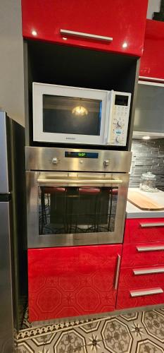 a microwave oven sitting on top of a red cabinet at Appartement tout équipé - Centre-ville EPERNAY in Épernay