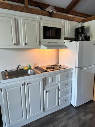 a kitchen with white cabinets and a sink and a refrigerator at Aqua Lodges At Hurricane Hole Marina in Key West