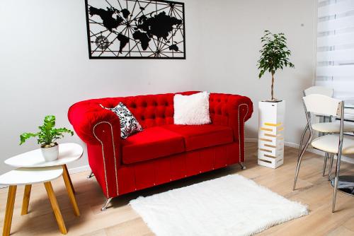 a red couch sitting in a living room at Movistar Arena "Rincón de ensueño" Palermo in Buenos Aires