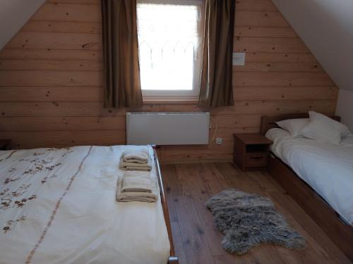 a bedroom with a bed and a window with towels at Domek z widokiem in Istebna
