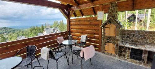 a porch with a table and chairs and a fireplace at Apartamenty EDEN in Karpacz