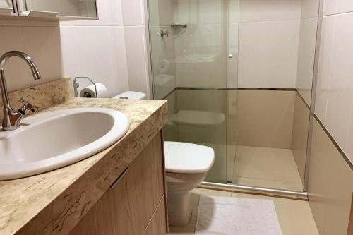 a bathroom with a sink and a toilet and a shower at Apto c/vista próx a faculdade /hospitais PC2302 in Goiânia