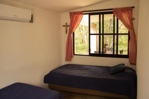 um quarto com uma cama e uma janela em Casa Rancho- Finca única en Yucatán em Hoctún