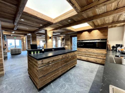 a large kitchen with wooden walls and a large island at chalet ormelune au pied des pistes in Sainte-Foy-Tarentaise