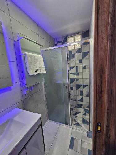 W łazience znajduje się szklana kabina prysznicowa i umywalka. w obiekcie THE CLIFF ALONA w mieście Alona