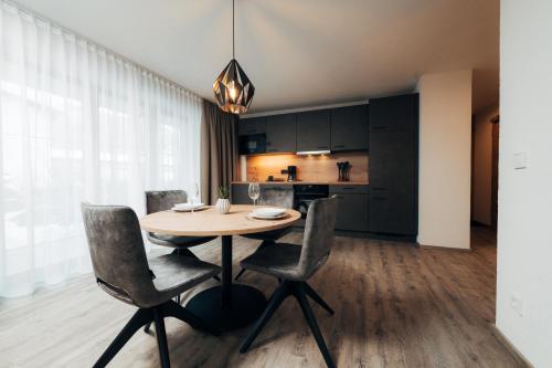 a kitchen and dining room with a wooden table and chairs at Living Mountain Tannheim in Tannheim