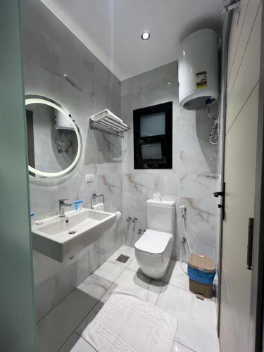 a white bathroom with a sink and a toilet at Regal view Aparthotel in Cairo