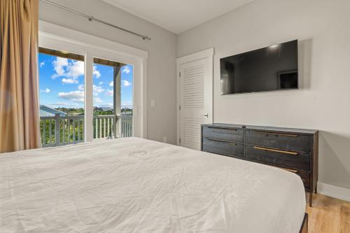 a bedroom with a large bed and a television at Zensation 14 Bedroom Home by KEES Vacations in Salvo