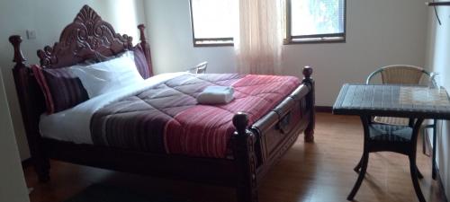 a bedroom with a large bed and a table at DISCOVERY COURTS HOTEL in Entebbe