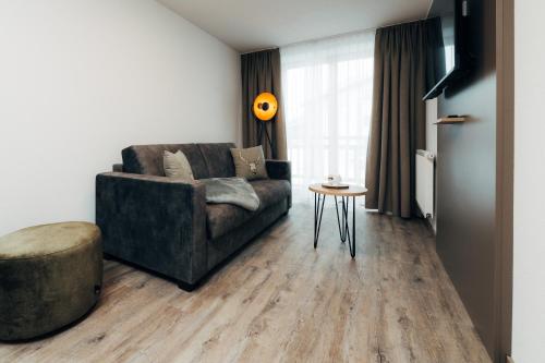 a living room with a couch and a table at Living Mountain Tannheim in Tannheim
