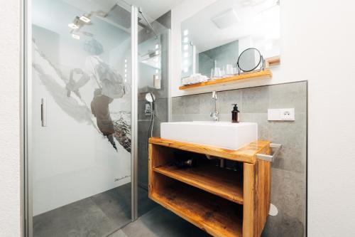 a bathroom with a sink and a shower at Living Mountain Tannheim in Tannheim