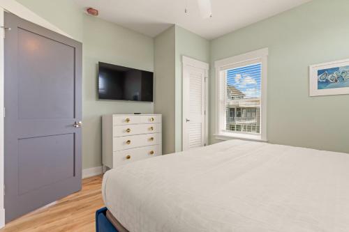 a bedroom with a bed and a tv and a window at Zensation 14 Bedroom Home by KEES Vacations in Salvo