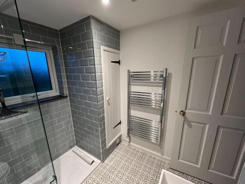 a bathroom with a shower and a glass door at Beech Cottage in Ilfracombe
