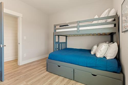 a bedroom with a bunk bed with blue sheets at Zensation 14 Bedroom Home by KEES Vacations in Salvo