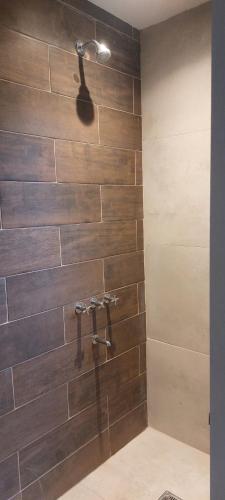 a bathroom with a shower with brown tiles at La Clarita , hospedaje boutique de descanso in Francisco Álvarez