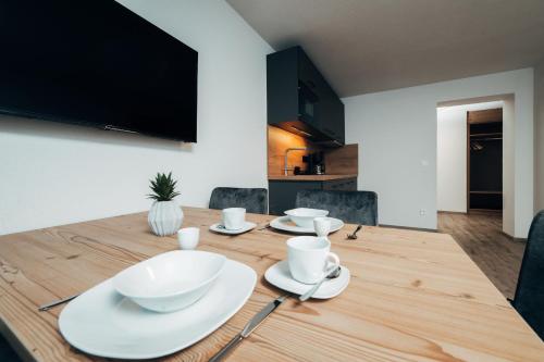 a dining room table with white dishes on it at Living Mountain Tannheim in Tannheim