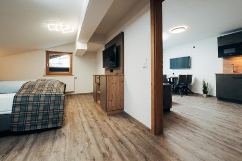 a room with a bed and a living room at Living Mountain Tannheim in Tannheim
