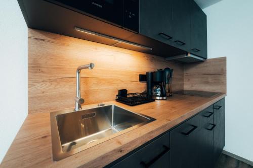 a kitchen with a stainless steel sink and a coffee maker at Living Mountain Tannheim in Tannheim