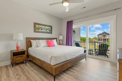 a bedroom with a bed and a balcony at Zensation 14 Bedroom Home by KEES Vacations in Salvo