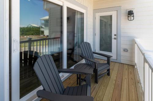two chairs sitting on the porch of a house at Zensation 14 Bedroom Home by KEES Vacations in Salvo