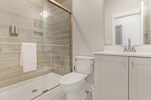 a bathroom with a toilet and a shower and a sink at Zensation 14 Bedroom Home by KEES Vacations in Salvo