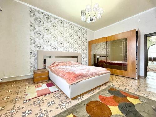 1 dormitorio con 1 cama grande y espejo en Spacious and cozy villa en Bishkek