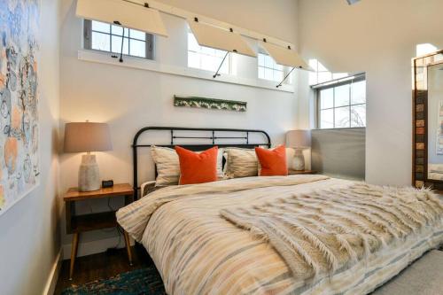1 dormitorio con 1 cama grande con almohadas de color naranja en Moab Digs - Your Downtown Basecamp!, en Moab
