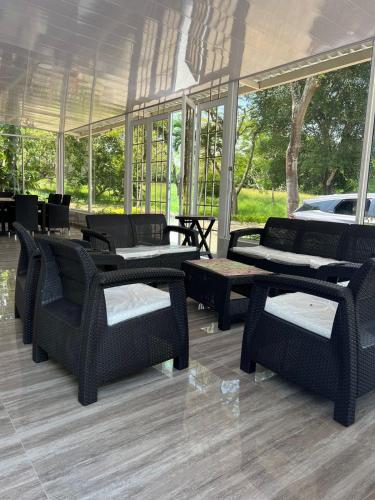 a group of chairs and tables in a room with windows at Finca Nirvana. in Agua de Dios