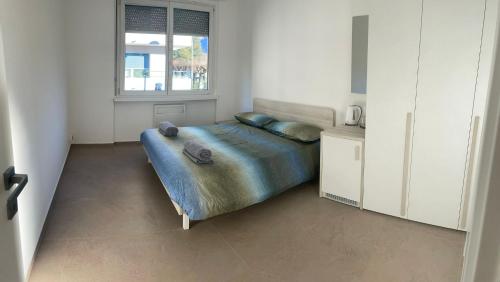 a bedroom with a bed with a blue blanket and a window at *Veranda's rooms* - Free parking in central Lugano in Lugano