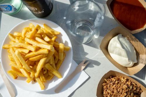 un plato de papas fritas y un tazón de crema agria en ufer75 Tiny Lodges am Nord-Ostsee-Kanal in Sehestedt, en Sehestedt