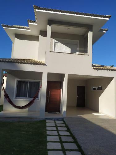 a white house with a door and a yard at Casa Excepcional na Praia Brava - Florianópolis in Florianópolis