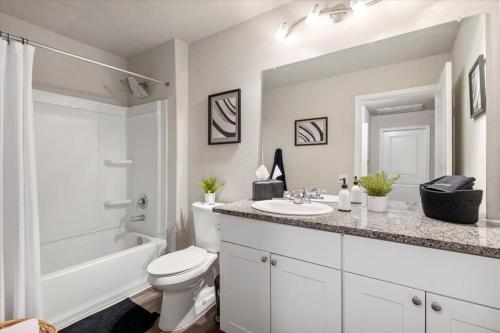 uma casa de banho branca com um lavatório e um WC em Pelican Crossing em San Antonio