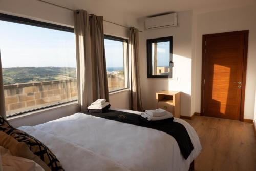 ein Schlafzimmer mit einem Bett und einem großen Fenster in der Unterkunft OneFifty Holiday Home in Il-Pergla