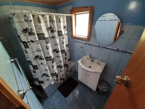 uma casa de banho com um lavatório, um WC e um espelho. em Cabaña Rústica Puqueldón em Puqueldón