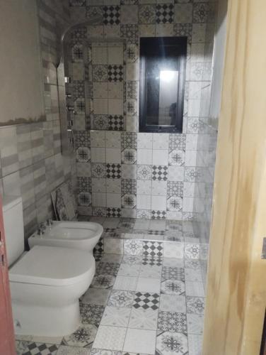 y baño con aseo y lavamanos. en Alquiler Duplex Cosquin en Cosquín