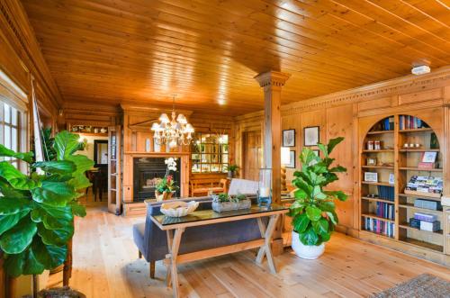 a living room with a wooden ceiling and a table at Inn On SummerHill in Summerland