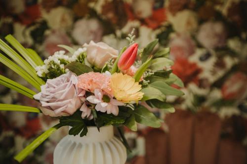 a white vase filled with a bouquet of flowers at The Garden Room at Waddington Flats in Victoria