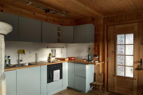 een keuken met witte kasten en een raam bij Traditional chalet in the heart of nature in Sarreyer