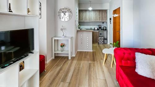 a living room with a red couch and a kitchen at Movistar Arena "Rincón de ensueño" Palermo in Buenos Aires