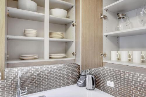 a kitchen with white plates and dishes on shelves at Tribeca Studio w Tons of light Gym Pool NYC-118 in New York
