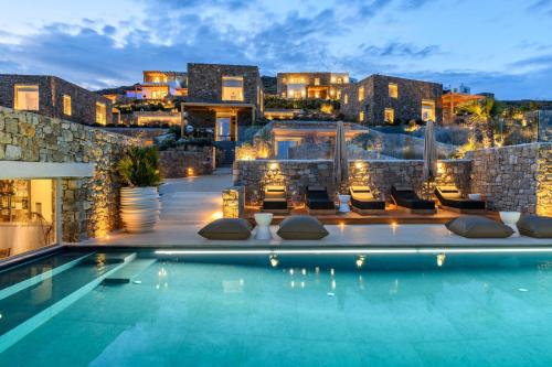 a villa with a swimming pool at night at The Mykonist Panormos Exclusive Suites & Villas in Mykonos