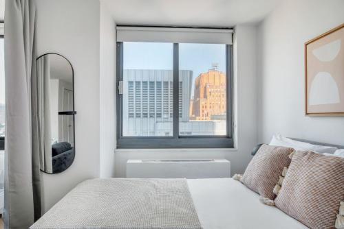 a bedroom with a window with a view of a city at Tribeca Studio w Tons of light Gym Pool NYC-118 in New York