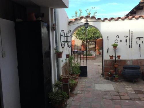 uma entrada para um edifício com um arco e vasos de plantas em Hostería El Zaguan em Cafayate