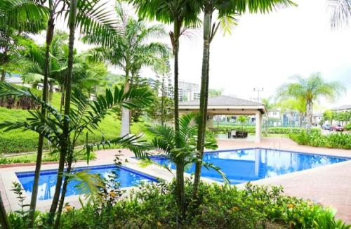 an image of a swimming pool at a resort with palm trees at Ecusuites Ceibos familiar Jacuzzi American Consulate- Vía a la Costa in Guayaquil