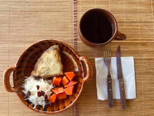 a basket of food with rice and carrots and a cup of coffee at Coco Viejo Posada in San Pedro Pochutla